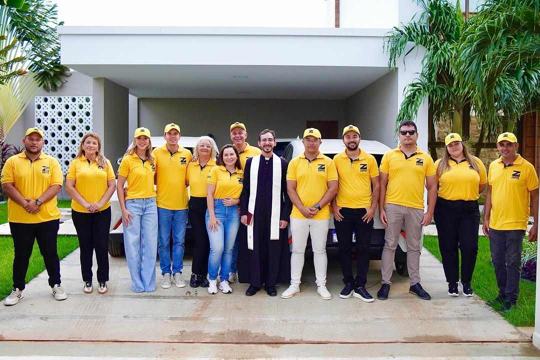 Equipe ZAPPO uniformizada em frente aos carros elétricos da frota